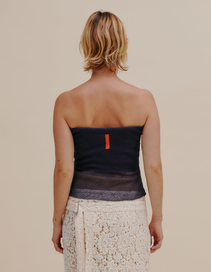 Seamlessly fully-fashioned knit tube top in a monofilament Italian yarn. Layered panels creates different levels of opacity. Complete with contrasting intarsia color blocking. Model wears size S. 100% polyester. Made in USA.