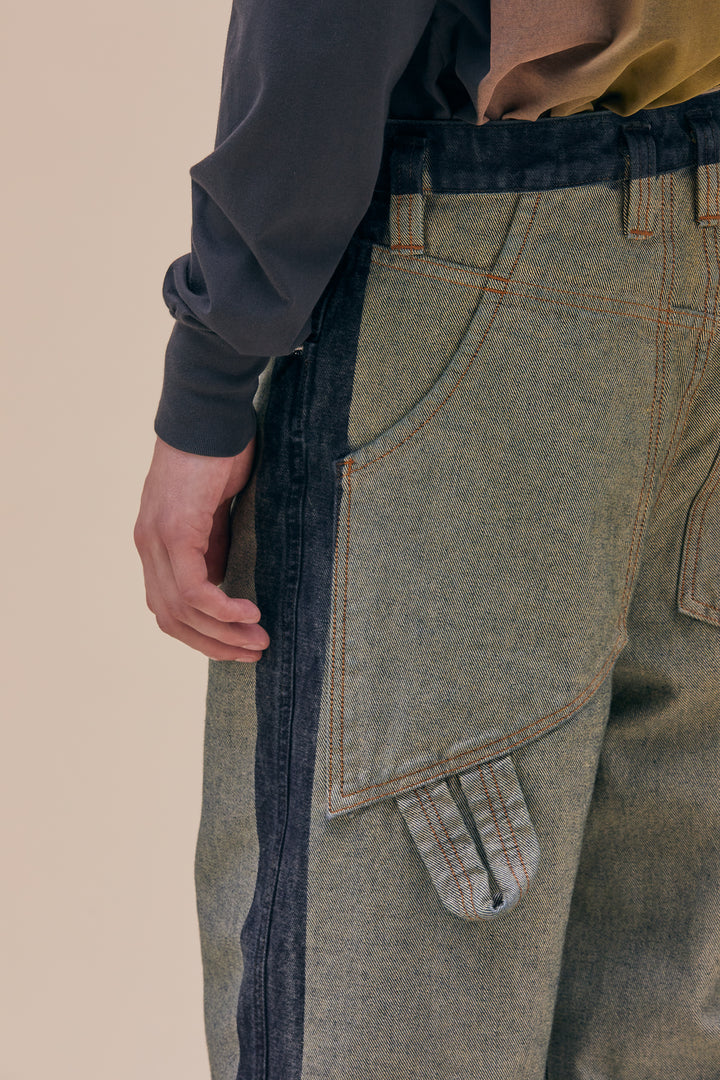 Our classic baggy jean silhouette is updated with a hand stenciled spray wash on the borders that creates a two toned effect on a soft green base. The jeans are distinguished with our trademark back pockets that are exaggerated in scale with a carpenter's hammer loop on the back left pocket. They have a zip fly closure with a logo shank on the waistband and rivets on the front pockets in nickel hardware. Models wear sizes 27 and 30. Made in USA. 100% cotton.