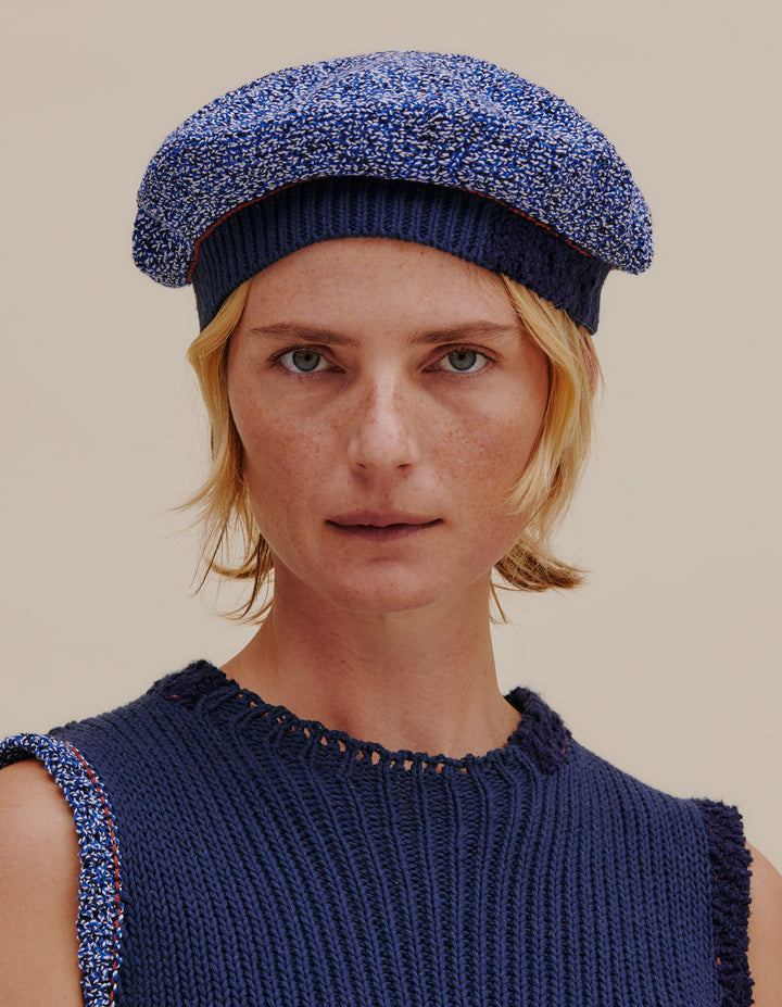 Fully fashioned knit beret made from a cotton and linen yarn blend. Contrast ribbed navy band. Model wears OS. 49% cotton, 49% linen, 2% poly. Made in China.