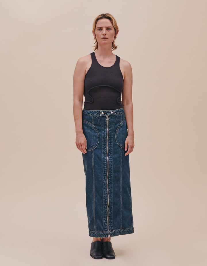 Mid-length skirt in garment washed denim with full-length exposed center zipper down the front and back. Featuring our “New Blue” enzyme wash with overdyed indigo. Slim fit and low rise with rounded pockets at the hip and an exaggerated yoke in the back. Finished with an extended waistband and nickel hardware. Model wears size S. Made in USA. 100% cotton.