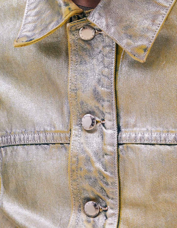 The newest addition to our denim collection, the EL jacket has a boxy, slightly cropped with with details that play on traditional denim finishing. This iteration featured our “Sterling” colorway. Indigo denim is enzyme washed, then overdyed in citrine, then entirely foiled in silver. Finished with nickel hardware. Model wears a size M. Made in USA. 100% cotton.