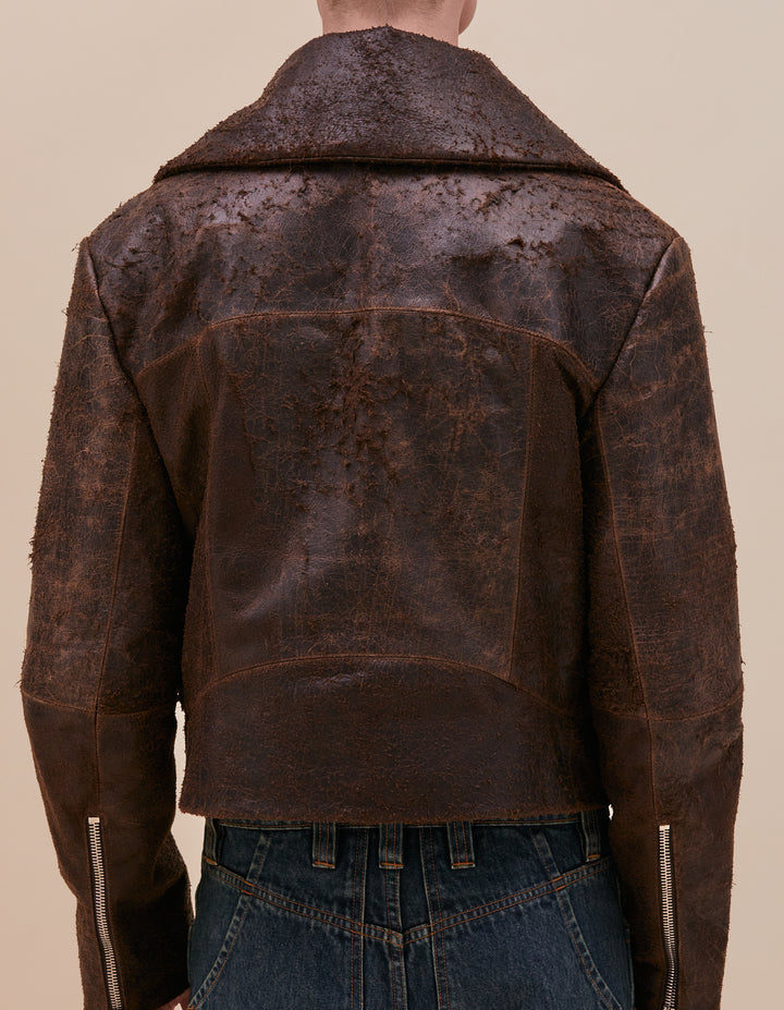 This jacket is crafted in distressed deadstock cow leather hand selected in Portugal. Cropped and boxy in fit, the garment is complete with a poet collar, tailored sleeves, welt pockets and zippers at center front and sleeve hem. Fully lined with a slight fill. Models wear size M. Made in Portugal. 100% leather, lining 100% polyester.