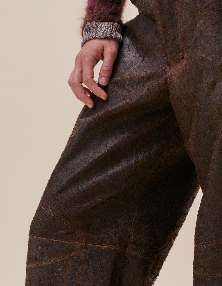 These pants are crafted in distressed deadstock leather hand selected in Portugal. Mid rise with a straight leg, semi lined. Curvilinear patchwork throughout the garment completes the garment. Made in Portugal. 100% leather, lining 100% polyester. Model wear sizes 27 and 30.