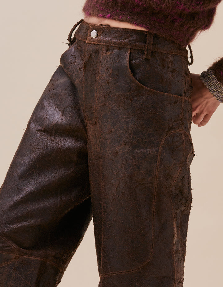 These pants are crafted in distressed deadstock leather hand selected in Portugal. Mid rise with a straight leg, semi lined. Curvilinear patchwork throughout the garment completes the garment. Made in Portugal. 100% leather, lining 100% polyester. Model wear sizes 27 and 30.