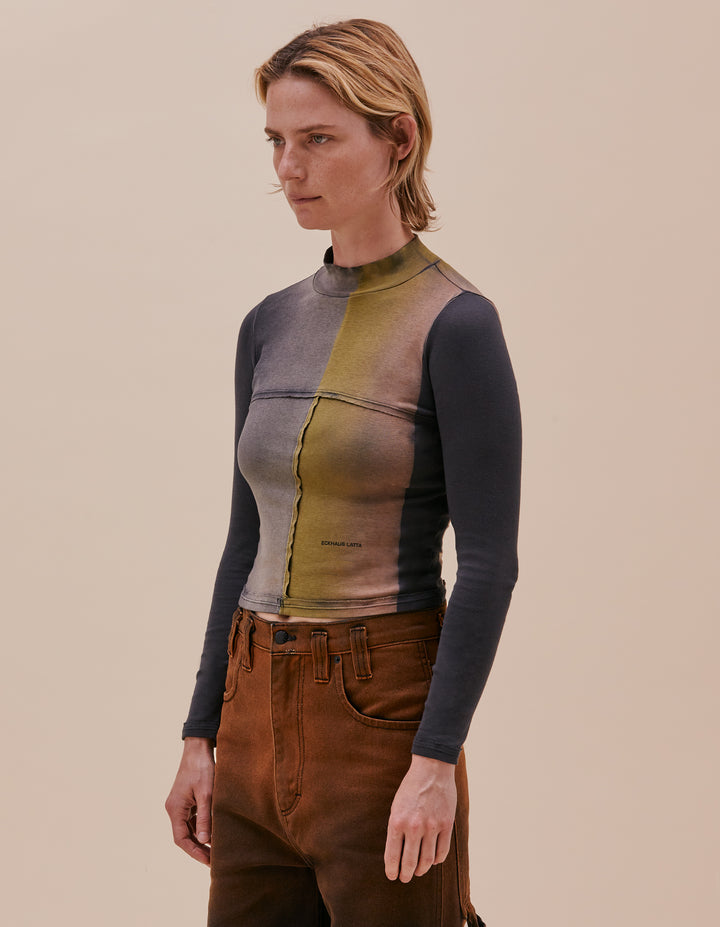Our classic lapped baby turtleneck is cut in a 1x1 cotton baby rib. The top is broken up into multiple lapped pieces, raw edged seams are highlighted with topstitching. This version features the colorway "inky" with a hand dyed colorful gradient. Our classic mini logo is screen printed at the left abdomen. Model wears size small. Made in Peru. 100% cotton.