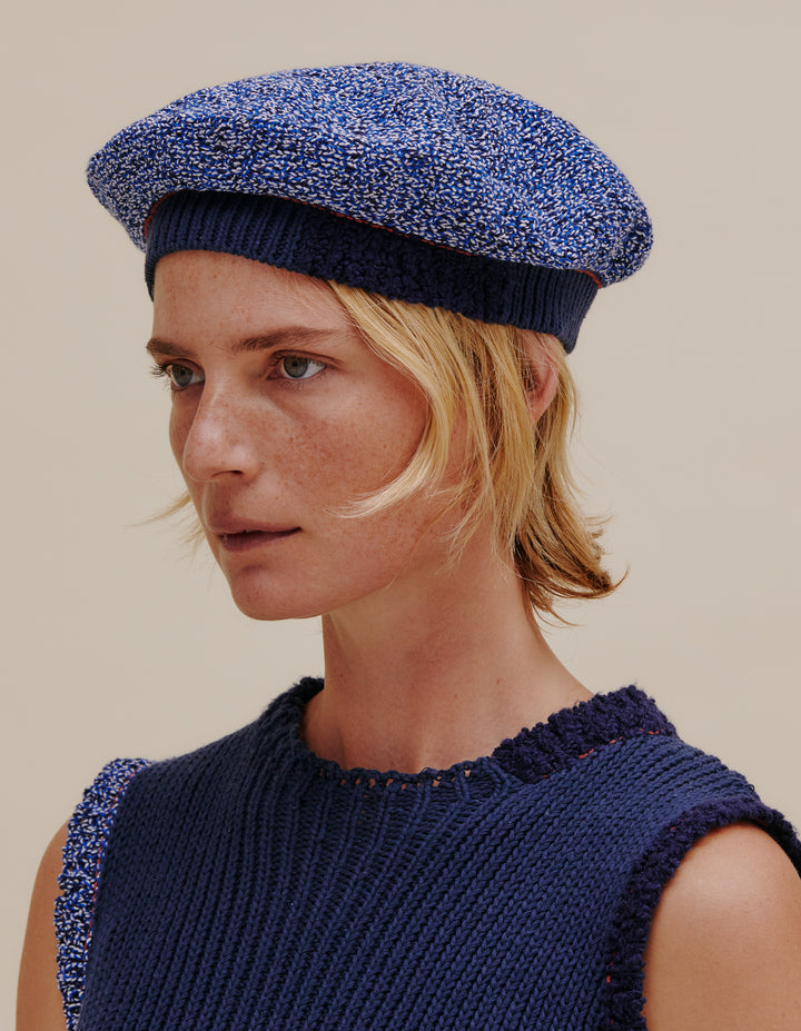 Fully fashioned knit beret made from a cotton and linen yarn blend. Contrast ribbed navy band. Model wears OS. 49% cotton, 49% linen, 2% poly. Made in China.