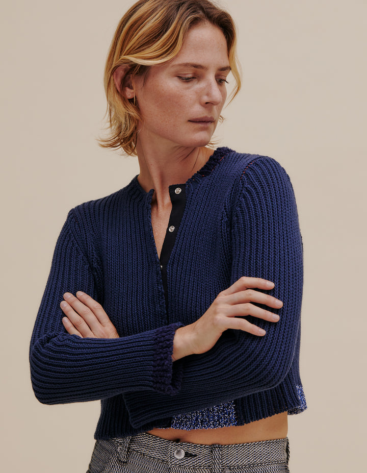 Ribbed cardigan made from a cotton and linen yarn blend. Contrasting color patches around hem, neckline and cuff. Finished with a snap front placket. Model wears size S. 49% cotton, 49% linen, 2% poly. Made in China.