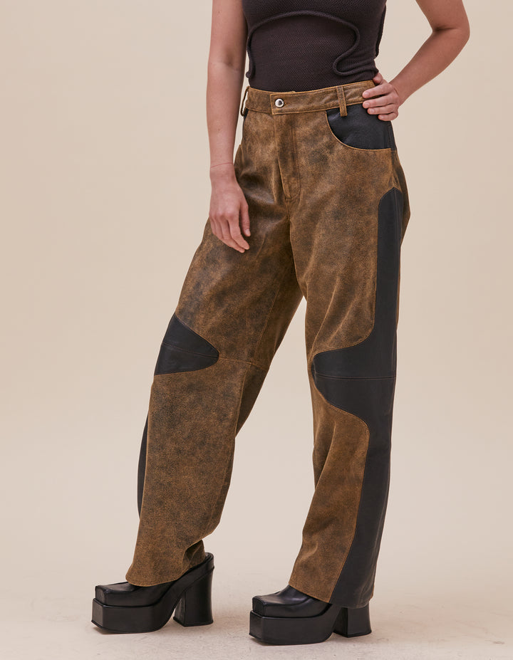 These pants are crafted in distressed deadstock leather hand selected in Portugal. Mid rise with a straight leg, semi lined. Curvilinear patchwork throughout the garment showcases the two distinct leather qualities. Made in Portugal. 100% leather, lining 100% polyester. Models wear sizes 27 and 30